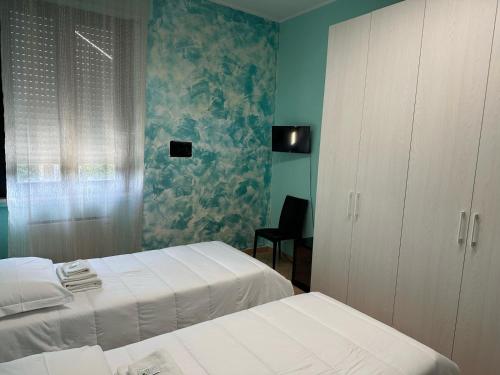 a bedroom with two beds and a cabinet and a chair at Locanda San Martino in Collecchio