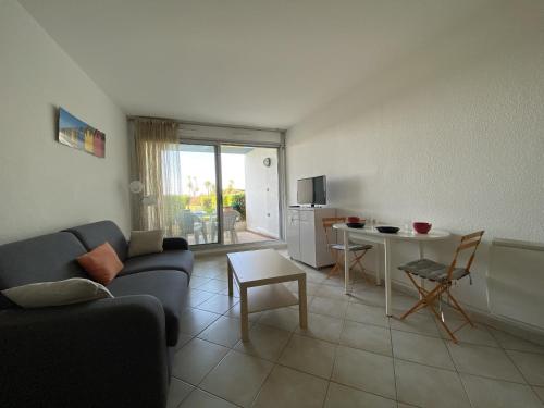 un salon avec un canapé et une table dans l'établissement Sol-y-Days Belles Plages RdJ bords de mer et piscine, à La Grande Motte