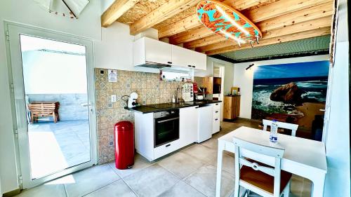 a kitchen with white cabinets and a red fire extinguisher at Cantinho do Pescador in Silveira