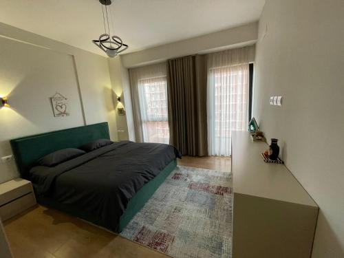 a bedroom with a bed with a green headboard at Garden Building Luxury Apartment in Tirana