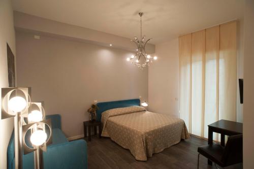 a bedroom with a bed and a chandelier at B&B Corso Diaz in Ravenna