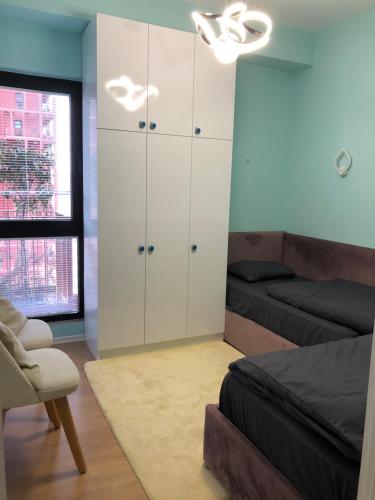 a bedroom with a bed and a white cabinet at Garden Building Luxury Apartment in Tirana
