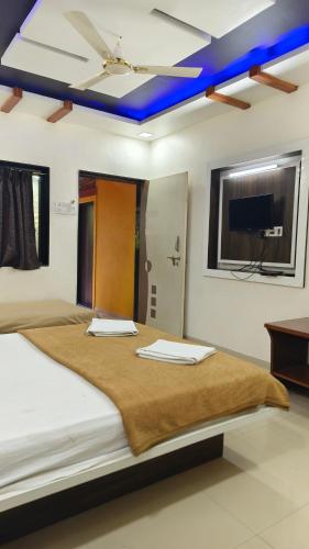 a bedroom with a large bed with a blue ceiling at Girichintan Bunglow in Mahabaleshwar