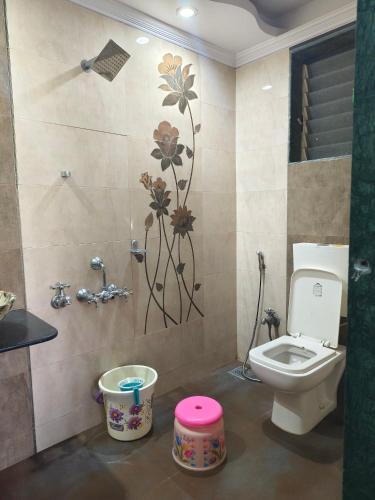 a bathroom with a toilet and a flower mural on the wall at Girichintan Bunglow in Mahabaleshwar