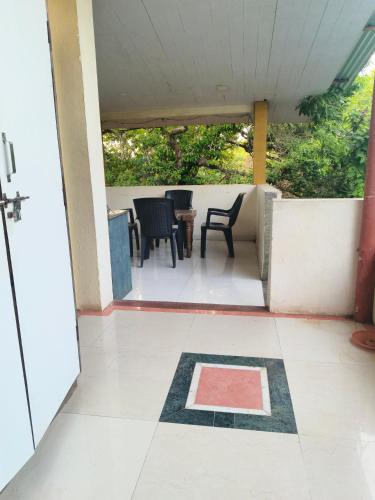 a patio with chairs and a table on a balcony at Girichintan Bunglow in Mahabaleshwar