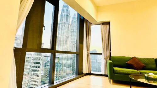 a living room with a green couch and a large window at Star Residence Suite KLCC in Kuala Lumpur