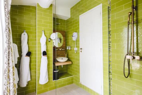 a green tiled bathroom with a shower and a sink at Le Palais d'Aglaé, Hôtel de Charme in Gordes