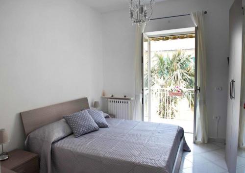 um quarto com uma cama e uma grande janela em Casa Fortuna em Nápoles