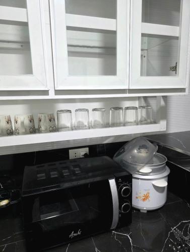 a kitchen counter with a coffee maker and a microwave at Mamadear's Bed & Breakfast in Suizo