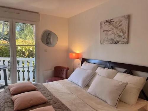 Cette chambre comprend un lit avec des oreillers et un balcon. dans l'établissement Villa élégante à Lacanau + piscine, à Lacanau
