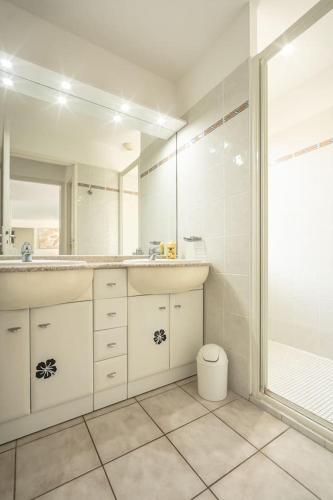 une salle de bain blanche avec un lavabo et une douche dans l'établissement Villa élégante à Lacanau + piscine, à Lacanau