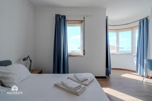 a bedroom with a bed with towels on it at Ericeira Panoramic Sea View Apartments in Ericeira