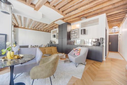 une cuisine et un salon avec une table et des chaises dans l'établissement Paris Marais City Heart, à Paris