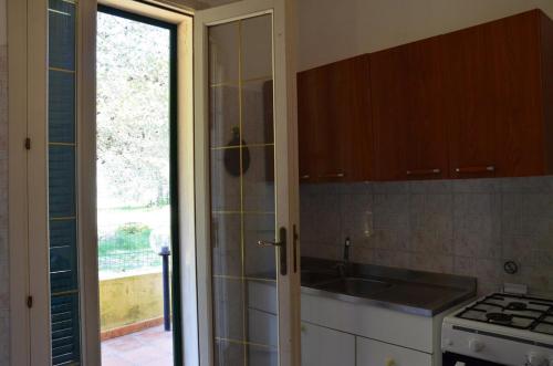 a kitchen with a sink and a stove at Padula Bianca - villa con accesso privato per la spiaggia in Rivabella