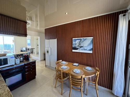 une cuisine avec une table et des chaises dans une cuisine dans l'établissement Grand appartement climatisé avec terrasses, vue mer, parking et WIFI - FR-1-335-173, à Hyères