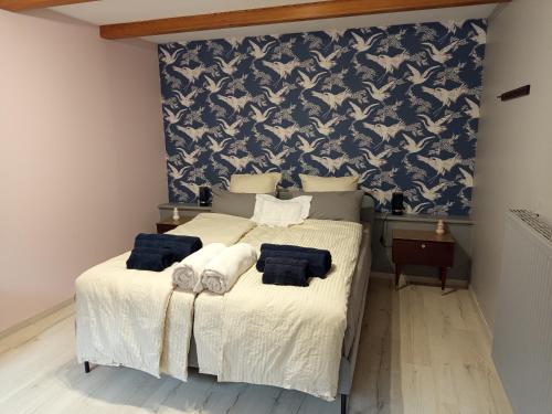 two beds in a bedroom with a blue and white wallpaper at Gîte 3 étoiles Le Charme Des Cerisiers pour 4 personnes in Bouvigny-Boyeffles