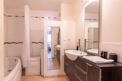 une salle de bain avec un lavabo, une baignoire et des toilettes dans l'établissement Le Galilée - Wifi - Balcon, à Angers