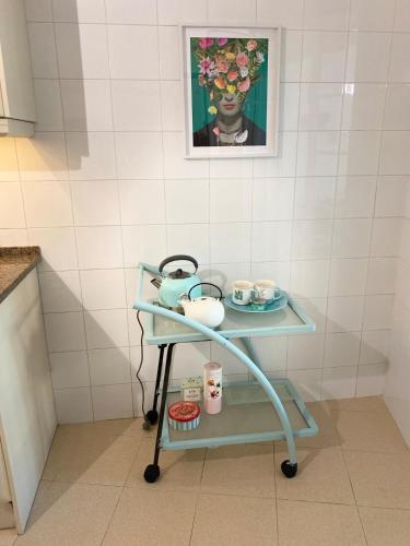 a cart in a kitchen with a painting on the wall at Casa da Joanita in Odeceixe