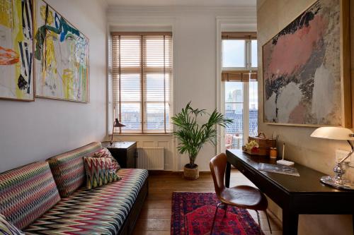 a living room with a couch and a desk at Babette Guldsmeden in Copenhagen