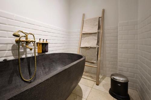 a bathroom with a tub and a towel rack at Babette Guldsmeden in Copenhagen