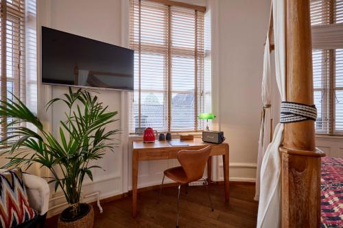 a bedroom with a desk in front of a window at Babette Guldsmeden in Copenhagen