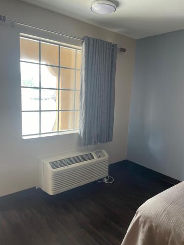 a bedroom with a window and a air conditioner at express inn motel in Hartselle