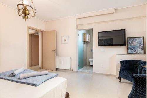a living room with a bed and a tv and a couch at Celeste Sea View Apartment Hot Tub 18 plus Adults only in Psalidi