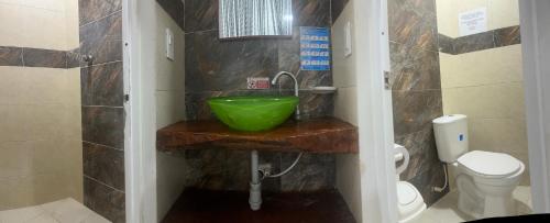 a bathroom with a green sink and a toilet at Hosteria Cattleya in San Andrés