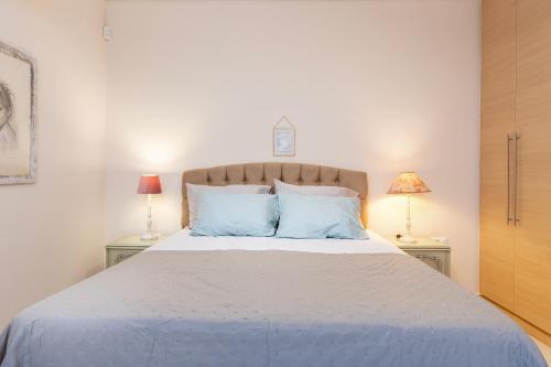 a bedroom with a large bed with blue pillows at Celeste Sea View Apartment Hot Tub 18 plus Adults only in Psalidi