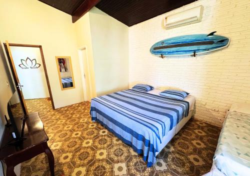a bedroom with a bed with a surfboard on the wall at Tombo Beach in Guarujá