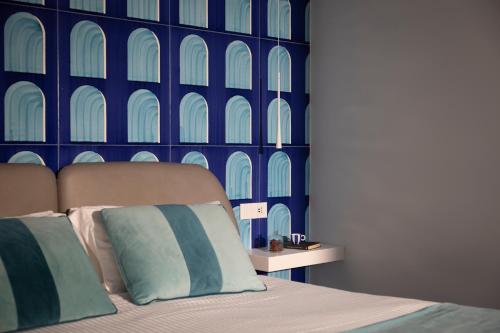Un dormitorio con una cama con una pared azul. en Di Capua House, en Massa Lubrense