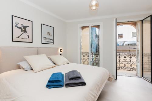 une chambre avec un lit blanc avec des serviettes dessus dans l'établissement Sublime appartement Forville Festival, à Cannes