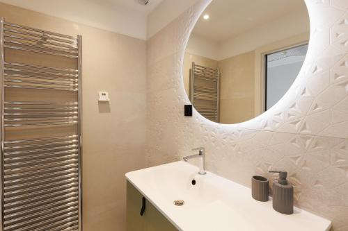 une salle de bain avec un lavabo et un miroir dans l'établissement Sublime appartement Forville Festival, à Cannes