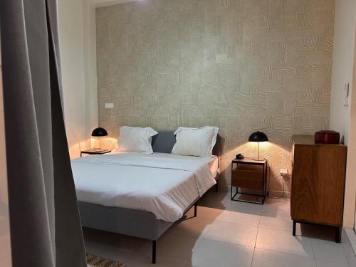 a bedroom with a bed with two night stands and two lamps at Aksil Jaam in Dakar