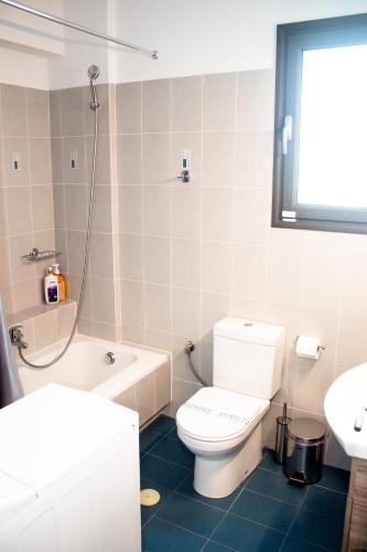 a bathroom with a toilet and a tub and a sink at EMVI APARTMENTS VII near airport,port and sea in Artemida