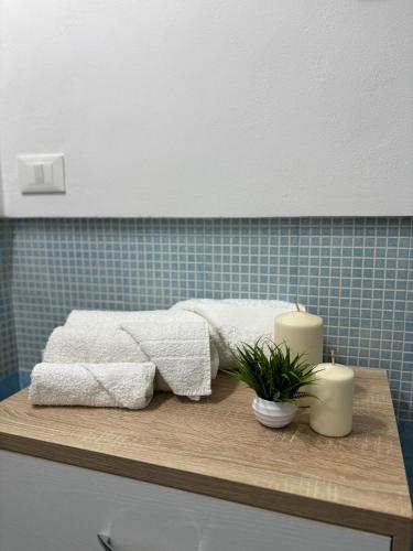 a bathroom with two towels and two candles on a table at Fridea in Trapani