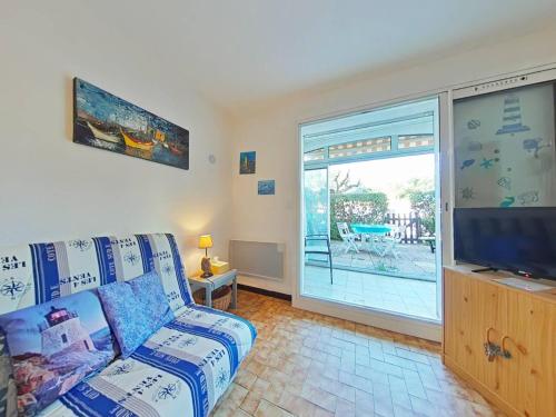 un salon avec un canapé et une télévision à écran plat dans l'établissement Appartement 2 pièces avec terrasse et piscine à La Londe-les-Maures - FR-1-826-7, à La Londe-les-Maures