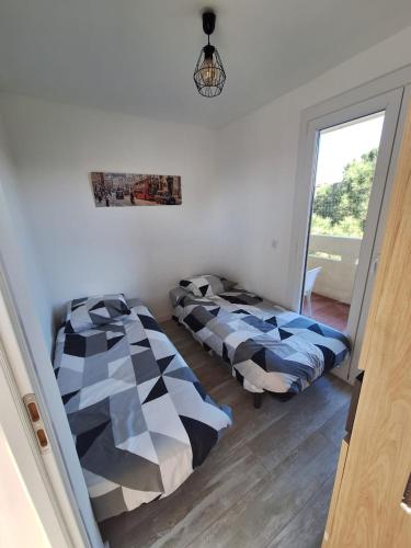 deux lits assis dans une pièce avec une fenêtre dans l'établissement Appartement Fréjus Plage - Port, à Fréjus