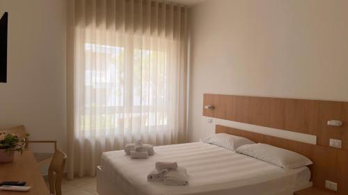 een slaapkamer met een bed met witte lakens en een raam bij Estelle in Bari