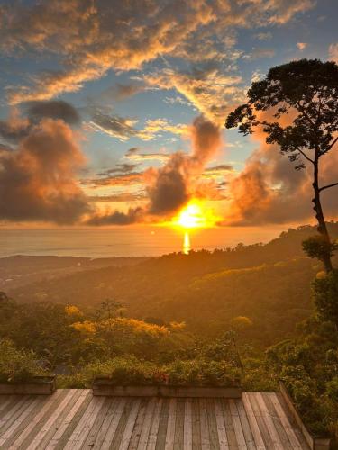 a view of a sunset from a wooden deck at Vista Celestial in Uvita
