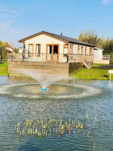 a fountain in the water in front of a house at Waterside Retreat in Wisbech