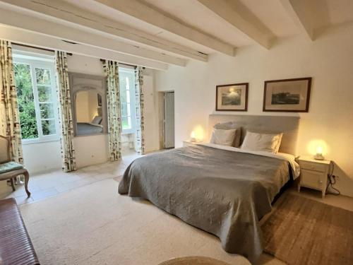 sypialnia z dużym łóżkiem i 2 lampami w obiekcie Gîte Rochellier - Charente-Maritime w mieście Cravans
