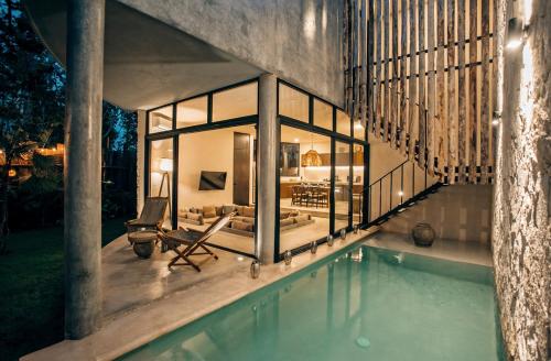 a house with a swimming pool next to a house at Jungle Boho Villa - Private Pool - Concierge 6B in Tulum