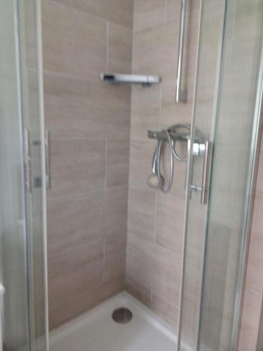une douche avec une porte vitrée dans une salle de bain dans l'établissement Zen House Very close to Paris, à Villejuif