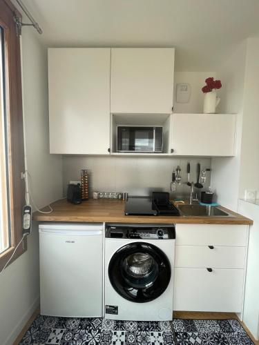 une cuisine avec un lave-linge et un micro-ondes dans l'établissement Studio panoramic view -Stade de France- Montmartre, à Saint-Denis