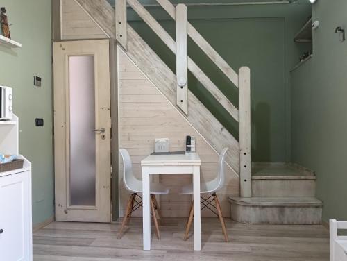 a table and chairs in a room with a staircase at La Casetta in San Maurizio Canavese