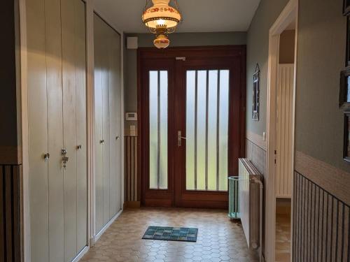 a hallway with a door and a chandelier at Maison familiale charme à Wavrille, proche Verdun - FR-1-585-169 in Wavrille