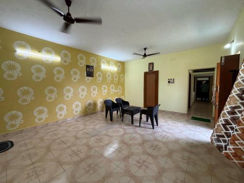 a dining room with chairs and plates on the wall at V2V Homestay in Mayiladuthurai