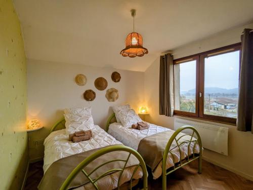 two beds in a room with a window at Maison familiale charme à Wavrille, proche Verdun - FR-1-585-169 in Wavrille