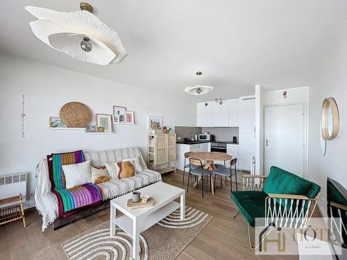 un salon avec un canapé et une table dans l'établissement L'Ancre Douce Sea View, à Bray-Dunes